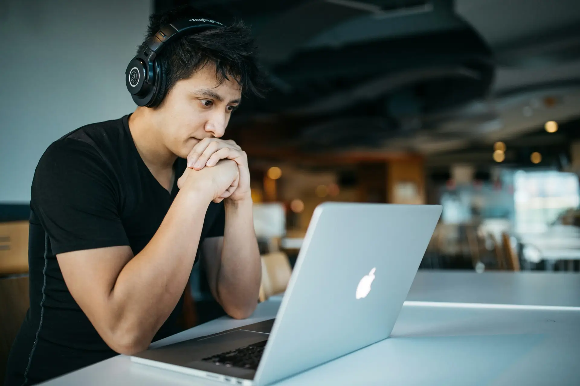 Man wearing headphones working on laptop at a table