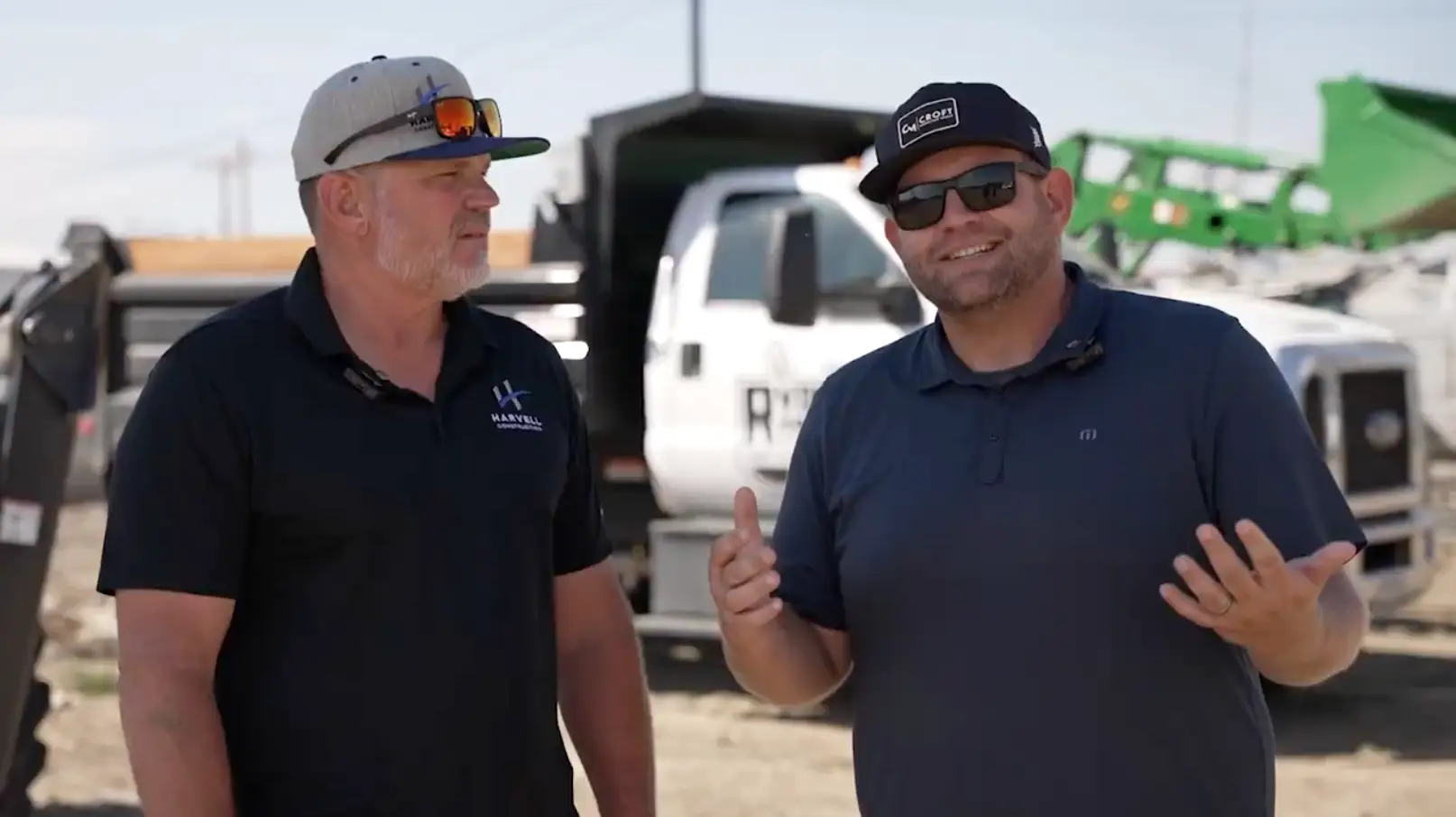 Harvell Founder and CROFT Founder speaking on site with work trucks in background