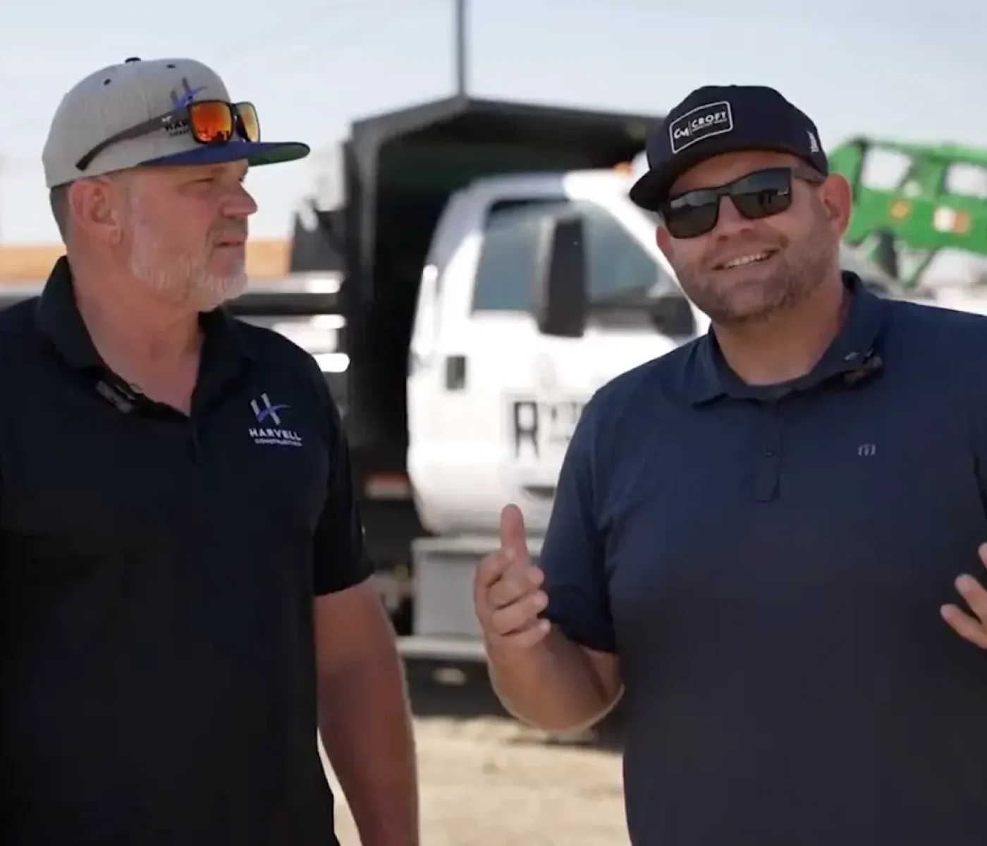Ryno Rentals Founder and CROFT Founder speaking on site with work trucks in background